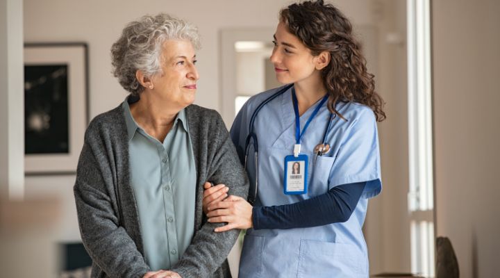 What is a practical nurse? A practical nurse smiles as she escorts an elderly patient by the arm down the hallway.